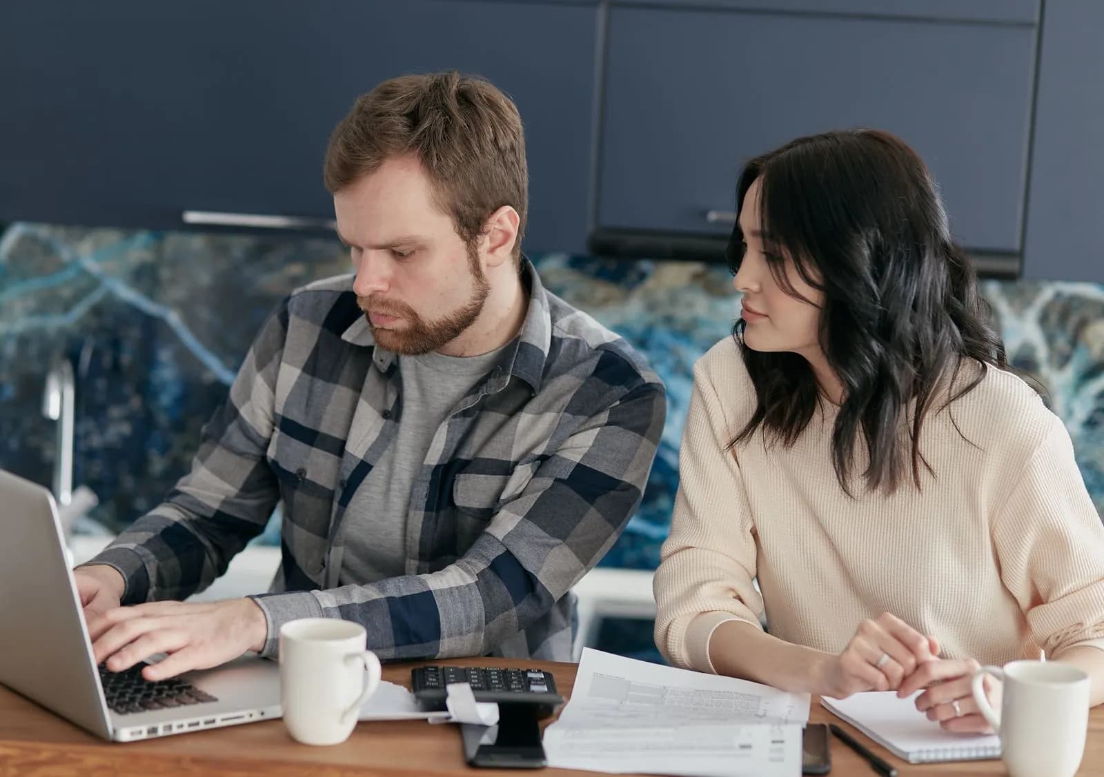 A couple reviewing paperwork together at a laptop