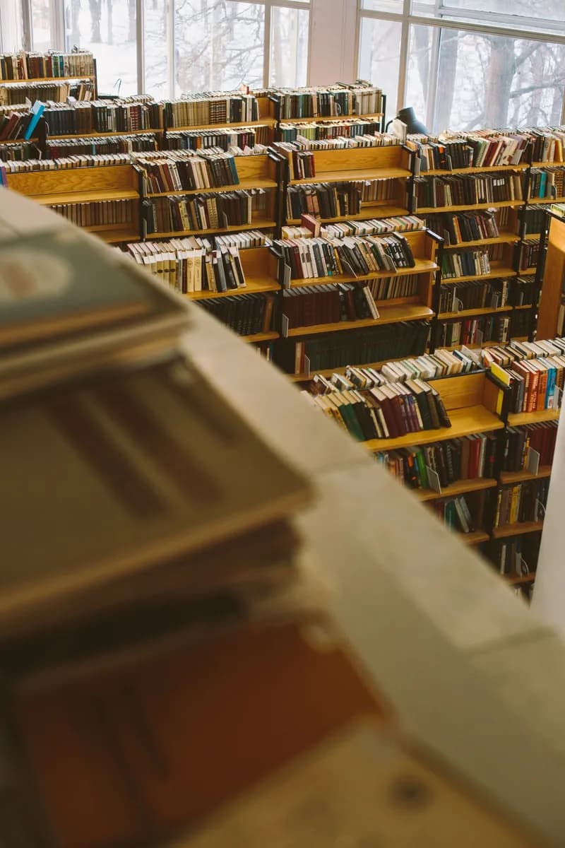 A warm and inviting library with rows of bookshelves filled with diverse literature.